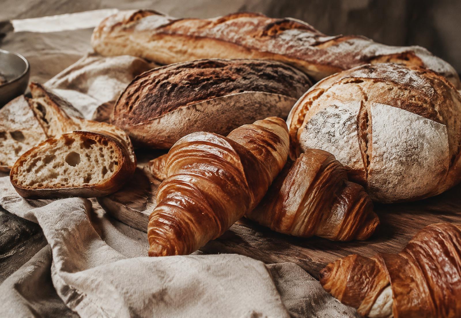 Panes y croissants sobre una mesa rústica — foto de referencia